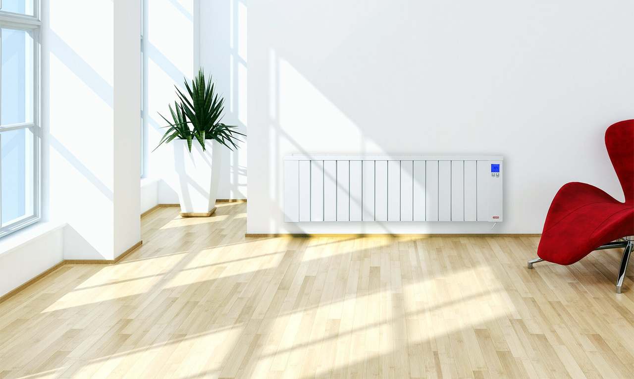 Lage Jawotherm radiator onder een groot raam in een lichte woonkamer