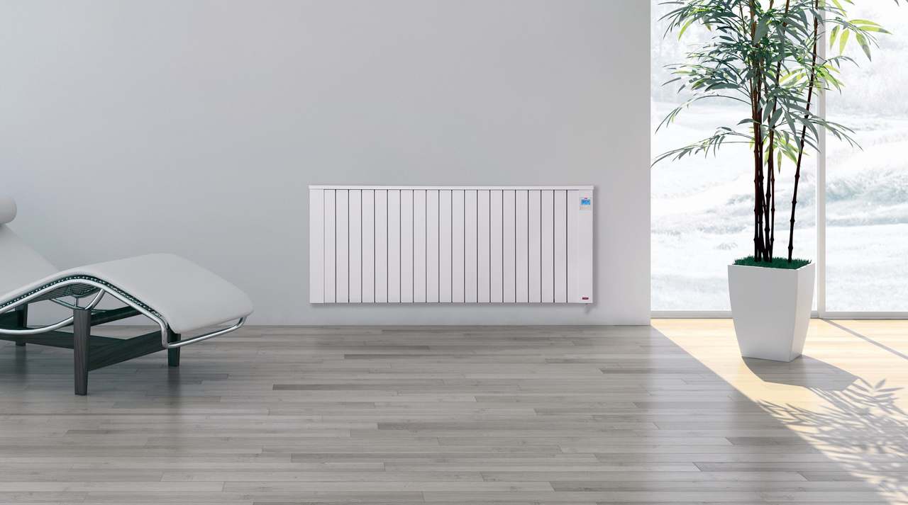 Woonkamer met ligstoel en een witte Jawotherm radiator aan de wand