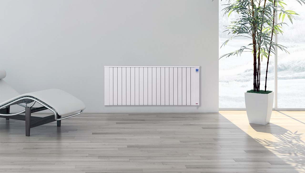 Witte Jawotherm radiator aan de wand van een lichte woonkamer met een plant